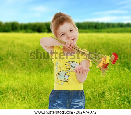 little girl in a yellow shirt holding a bouquet of flowers in front of him.cheerful summer holiday,active lifestyle,happiness concept,carefree childhood concept.