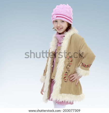charming girl in a warm coat.girl shows thumb.new year, warm clothing,happiness concept,happy childhood,carefree childhood,active lifestyle