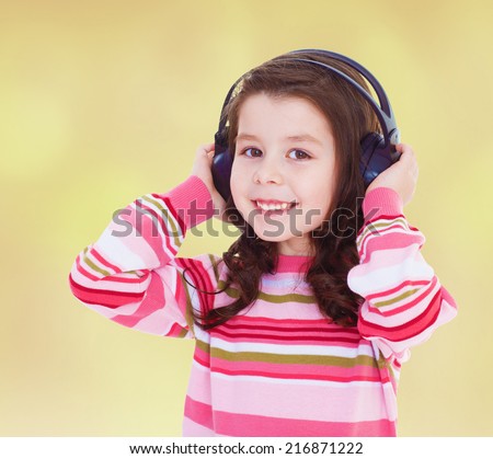 very musical little girl listening to music with your arms close to your ears.Concept of childhood and family values.