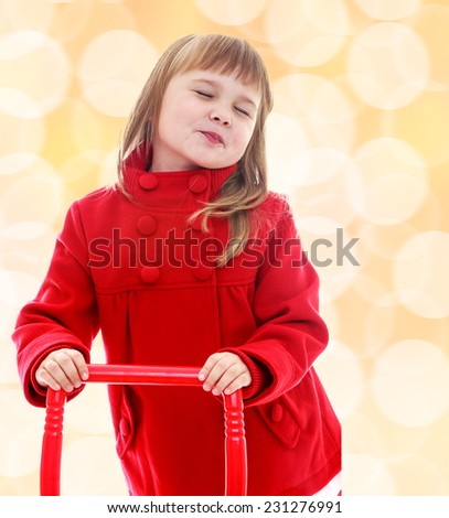 Cute little girl holding a red pen from the cart. Happiness, winter holidays, new year, and childhood.