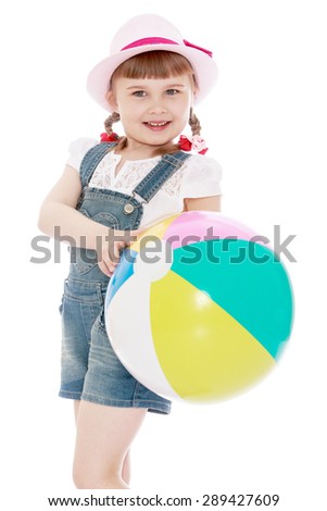 girl in a short denim overalls and hat holding a ball-Isolated on white background