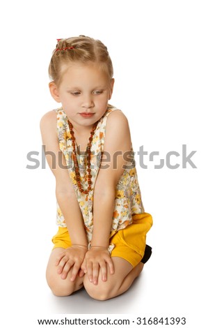 Think and think fashionable girl sitting on knees and looks down.neck girls long beads-Isolated on white background