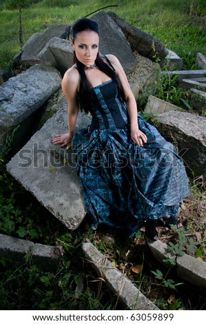 Woman wearing a designer industrial goth dress in an industrial setting