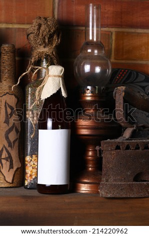 Bottle of craft beer with a blank label template standing on a fireplace shelf with various vintage objects