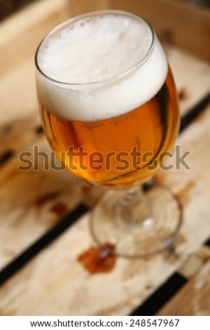 Glass of light beer in a grunge wooden crate