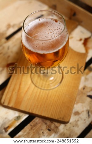 Glass of light beer in a grunge wooden crate