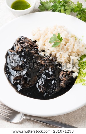 Squid in its own ink with brown rice and parsley sauce. Traditional Spanish recipe
