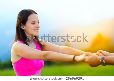 Woman holds hands with a man in nature