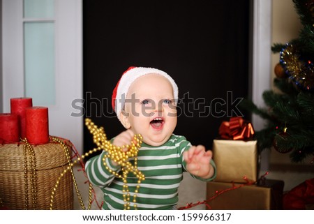happy boy in santa hat under xmas tree