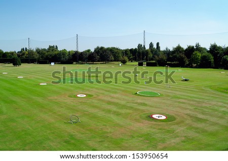 Golf driving range with yardage markers and targets.