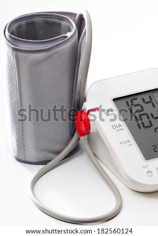 Electronic blood pressure meter and cuff. Meter display showing high blood pressure 154/104mm.