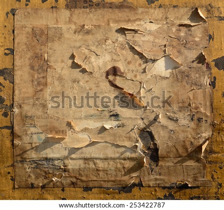 Torn paper address labels on old railways trunk as background. Multiple layers of old paper labels with handwriting and remnants of older damaged and torn labels.
