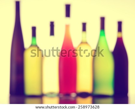 Abstract glass collection of wine bottles in various colors, shapes and sizes. Completely defocused, blurred and filtered.