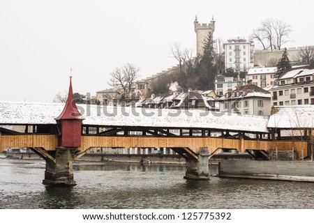 The mill bridge (SpreuerbrÃ?Â¼cke ) covered by snow, with the city wall tower on the background, Lucerne, Switzerland