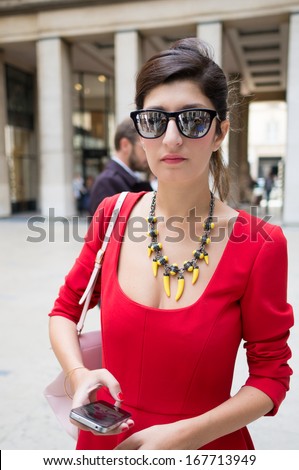 PARIS - OCTOBER 2: Stylish woman wears red robe during the Paris Fashion Week. Paris Fashion Week is a clothing trade show held semi-annually each year in Paris, France.