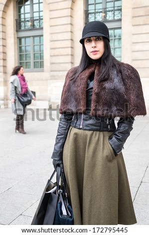 PARIS - JANUARY 23, 2014: Stylish European woman with leather shoulder cape at the Place Vendome. Paris Fashion Week: Haute Couture 2014/2015 is held in Paris from January 20 to 23, 2014.