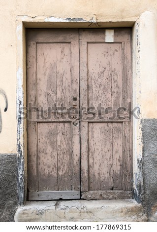Old simple dilapidated wooden door in Ventimiglia, Italy