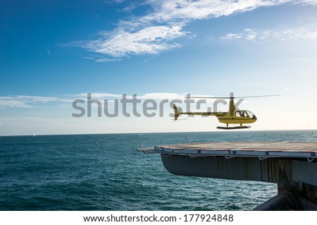 MONACO - FEBRUARY 13, 2014: A  helicopter lands on the plat form above the sea in the Monte Carlo International Heliport. This heliport is the only aviation facility in the principality.