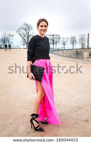 PARIS - MARCH 1, 2014: Stylish European woman with pink skirt and black high heels in the Tuileries Garden. Paris Fashion Week: Ready to Wear 2014/2015 is held from February 25 to March 5, 2014.
