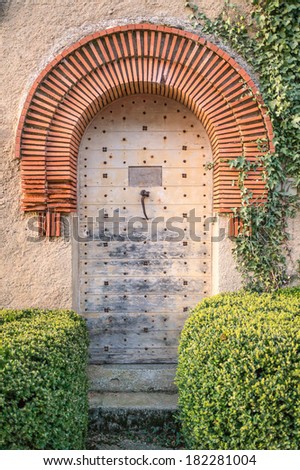 Old wooden door with red brick arch