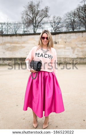 PARIS - MARCH 1, 2014: Stylish European woman with sunglasses and pink skirt in the Tuileries Garden. Paris is one of the capitals of fashion in the world.