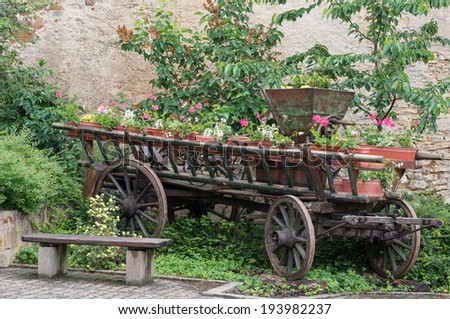 Old carriage full of flowers in Mittelbergheim, Alsace, France
