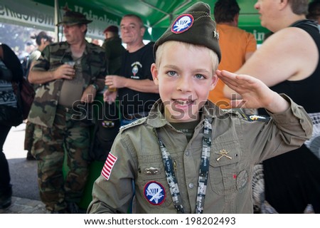 SAINTE-MERE-EGLISE, FRANCE - JUNE 6, 2014: Child salutes in the uniform of American army in the Second World War during the commemoration of the 70th anniversary of D-Day.