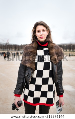 PARIS - MARCH 1, 2014: European woman with leather jacket and checkerboard pattern pullover in the Tuileries Garden. Paris is one of the capitals of fashion in the world.