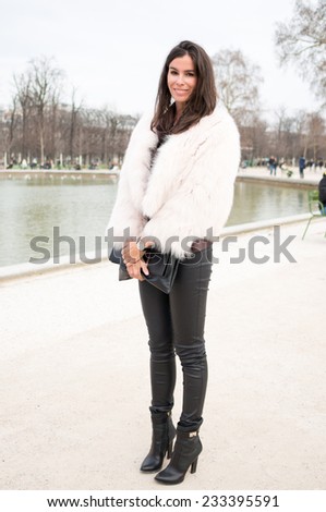 PARIS - MARS 5, 2013: Stylish European woman with white coat and black leather trousers in the Tuileries Garden. Paris Fashion Week: Ready to Wear 2013/2014 is held from February 26 to March 6, 2013.