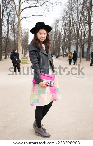 PARIS - MARS 5, 2013: Stylish Asian woman with colorful skirt and black leather jacket in the Tuileries Garden. Paris Fashion Week: Ready to Wear 2013/2014 is held from February 26 to March 6, 2013.