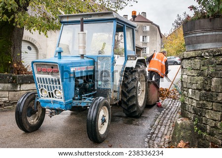 CHATEAU-CHALON, FRANCE - NOVEMBER 11, 2014: Dustman cleans the street with an old Ford tractor.