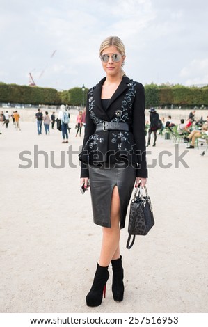 PARIS - SEPTEMBER 30, 2014: Stylish european woman with black leather skirt in the Tuileries Garden. Paris Fashion Week: Ready to Wear 2014/2015 is held from September 23 to October 1, 2014.