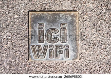 Metal wifi sign on the pavement with the incription of \