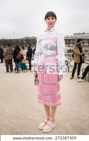 PARIS, FRANCE - MARCH 10, 2015: Stylish European woman with pink transparent skirt in the Tuileries Garden. Paris Fashion Week: Ready to Wear 2015/2016 is held from March 3 to 11, 2015.