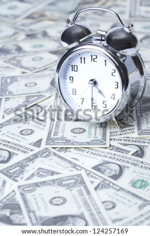 Alarm clock on US paper currency, close up