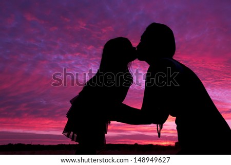 Mother and daughter silhouette kiss in the sunset in Sweden outside Stockholm