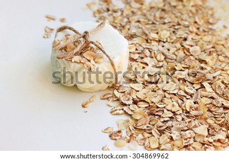 handmade bar of oatmeal soap organic healthy skin care white beige tones flakes scrub natural shallow DOF