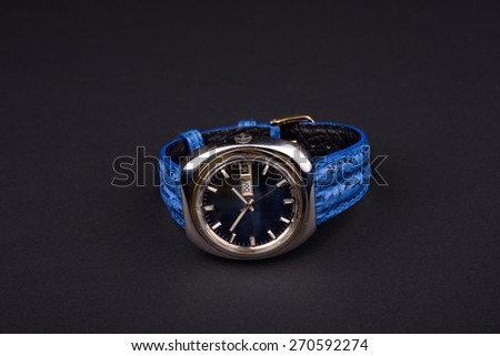 Old men\'s classic watch with blue strap on black background