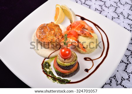 Cooked shrimp prepared with basil, lemon with vegetables, all served on a square white ceramic plate