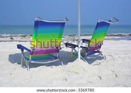 Two colorful chairs on the white sand