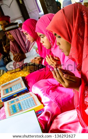 BANGKOK - APRIL 13 : Unidentified children pray for Allah for ceremony in Graduation of the Quran on April 13, 2013 in Bangkok, Thailand.