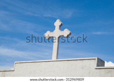 Cross tomb on blue sky background