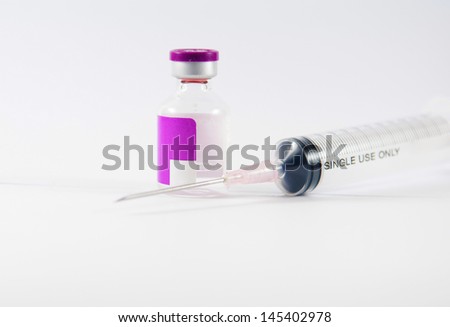 Purple label ampule and disposable syringe on white background