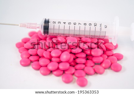 Closed up pink tablet and disposable syringe