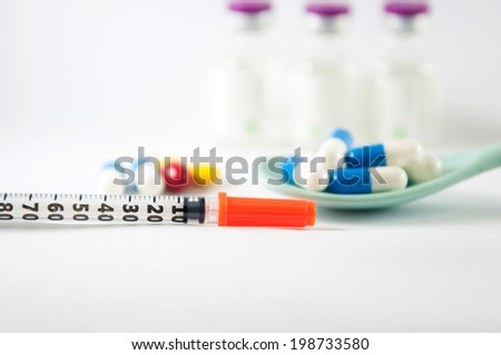 Disposable syringe on injection vials and capsule in spoon