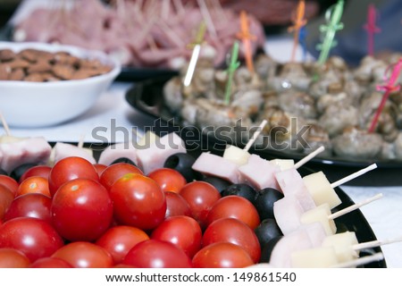 Cold snacks on the table : cherry tomatoes, canapes and meat snacks