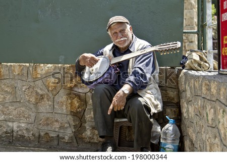 ANTALYA, TURKEY - MAY 14: Old street musician with a guitar in hand asking for money from tourists. May 14, 2014 in Antalya, Turkey.