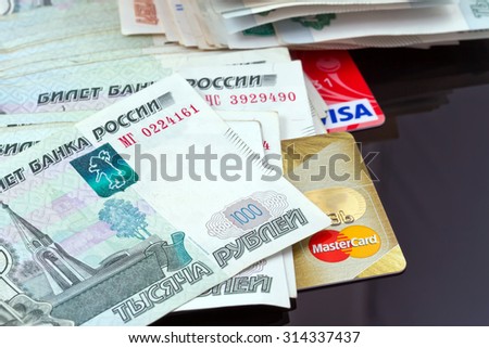 VOLGOGRAD - AUGUST 16: Plastic card payment systems Visa and MasterCard are with a bunch of Russian money . August 16, 2015 in Volgograd, Russia.