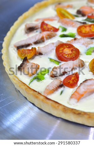 Delicious variation for quiche pie and pizza - pie with thickened cream and cottage cheese, salmon, green capsicum and cherry tomatoes cut in halves. Selective focus, copy space