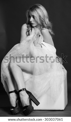 Studio, black and white photo of a girl ballerina, in a flying skirt, on black background